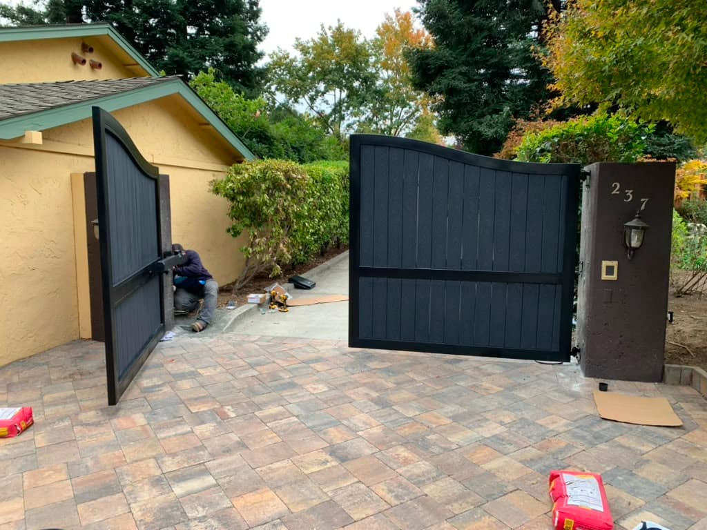 Arched wood-slat automatic gate with a black steel frame at a Contra Costa County estate